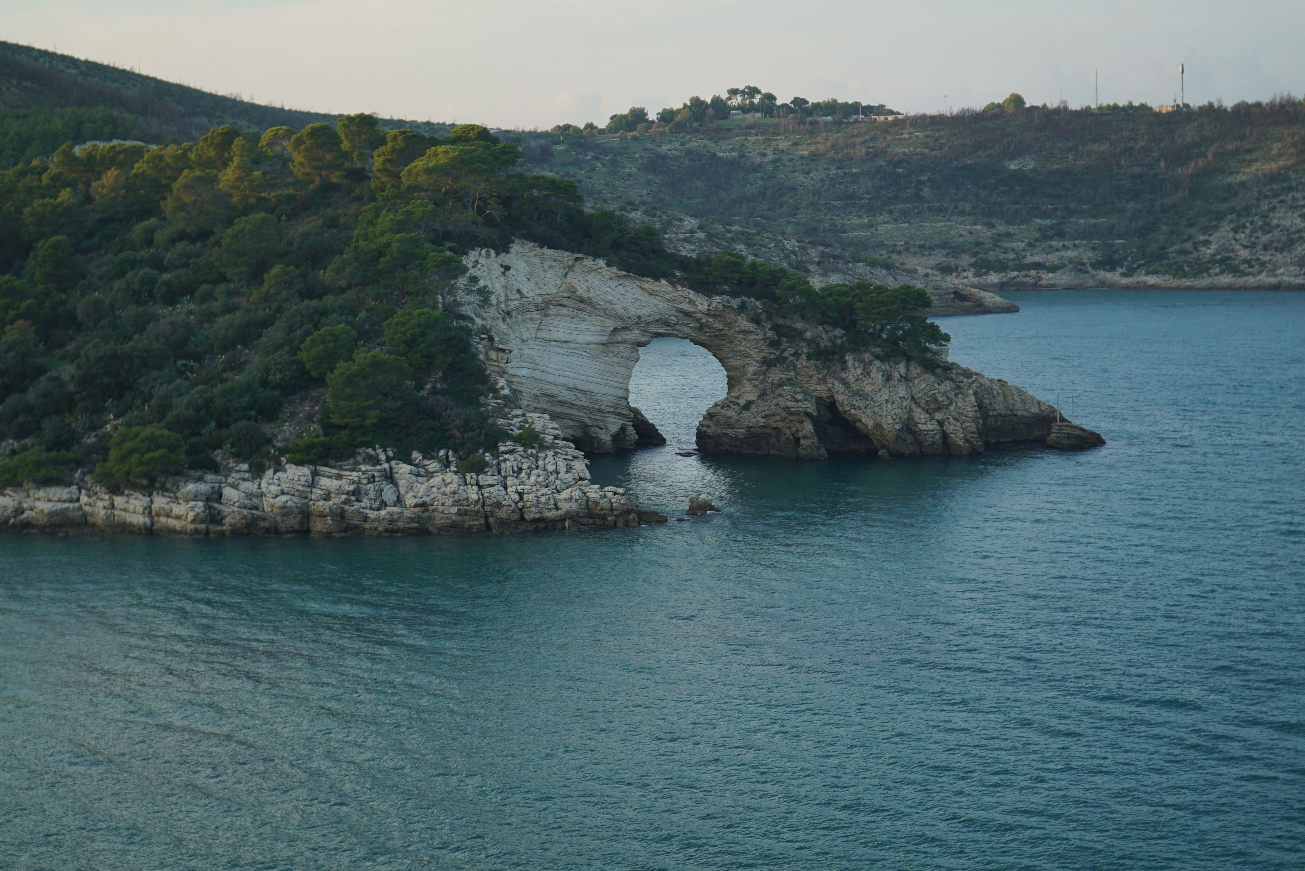Stunning view of a natural rock arch along the Gargano coastline in Italy