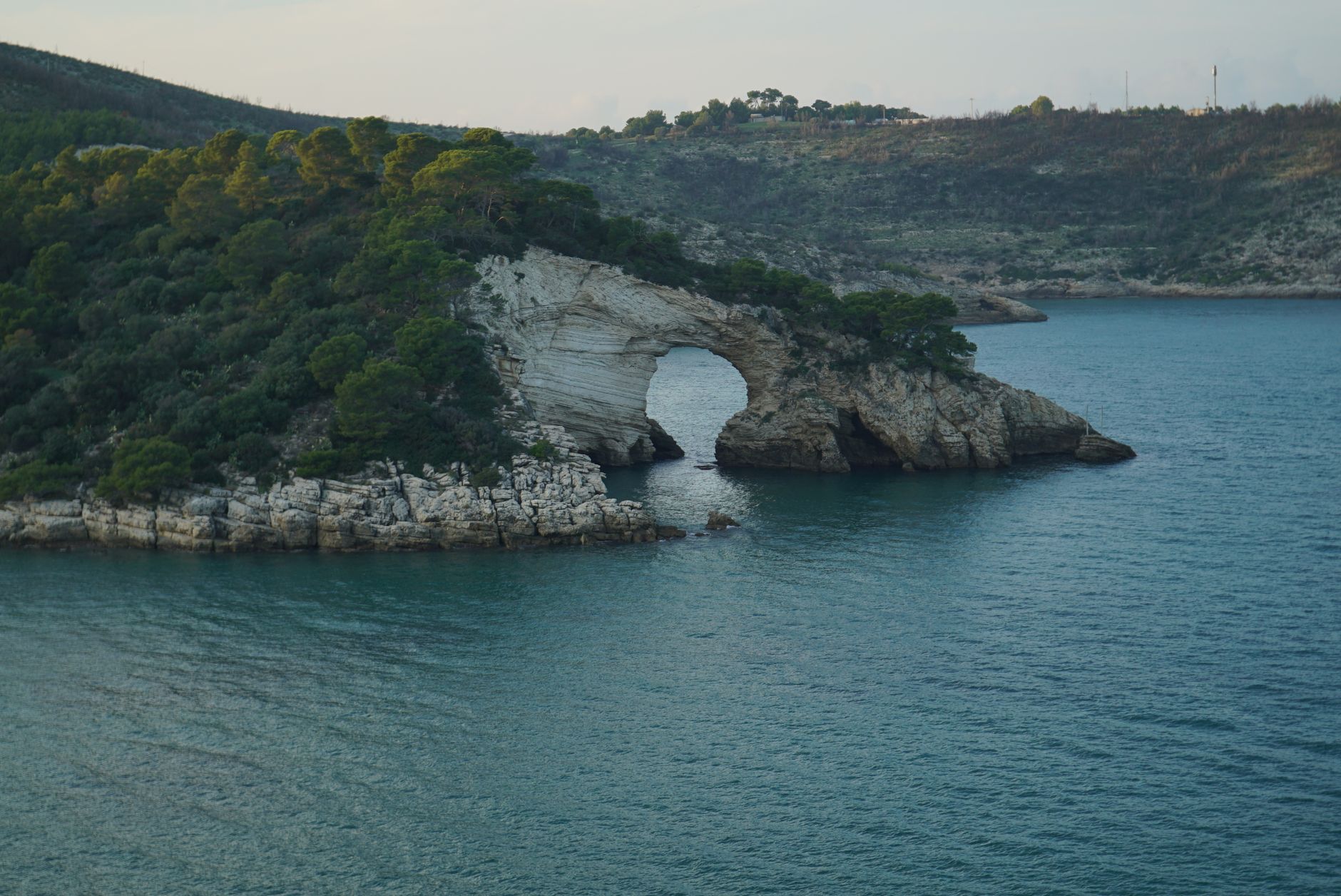 Stunning view of a natural rock arch along the Gargano coastline in Italy