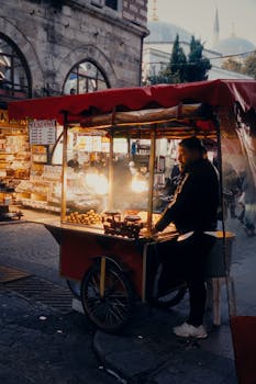 Warm street scene of a vendor selling roasted chestnuts in İstanbul at night.