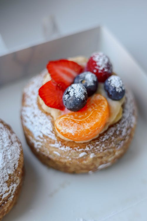 Free Close-up of a fruit-topped puff pastry with powdered sugar perfect for dessert lovers. Stock Photo