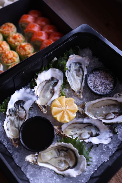 Free A mouth-watering display of fresh oysters on ice with lemon wedges and dipping sauce, ready to enjoy. Stock Photo