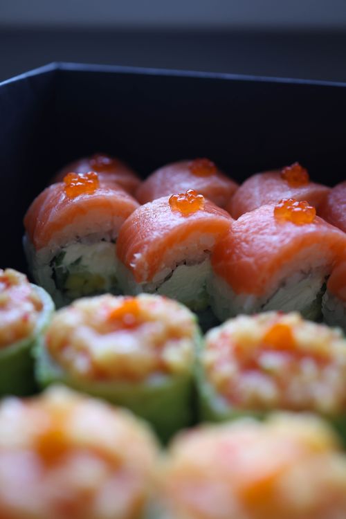 Free Close-up of vibrant sushi rolls with fresh salmon and roe topping, showcasing Japanese cuisine. Stock Photo