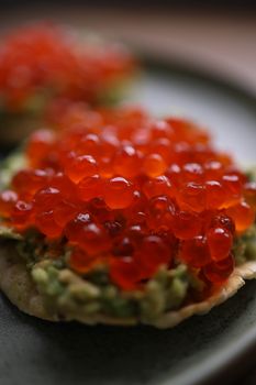 Delicious red caviar on avocado toast, perfect gourmet snack or appetizer.