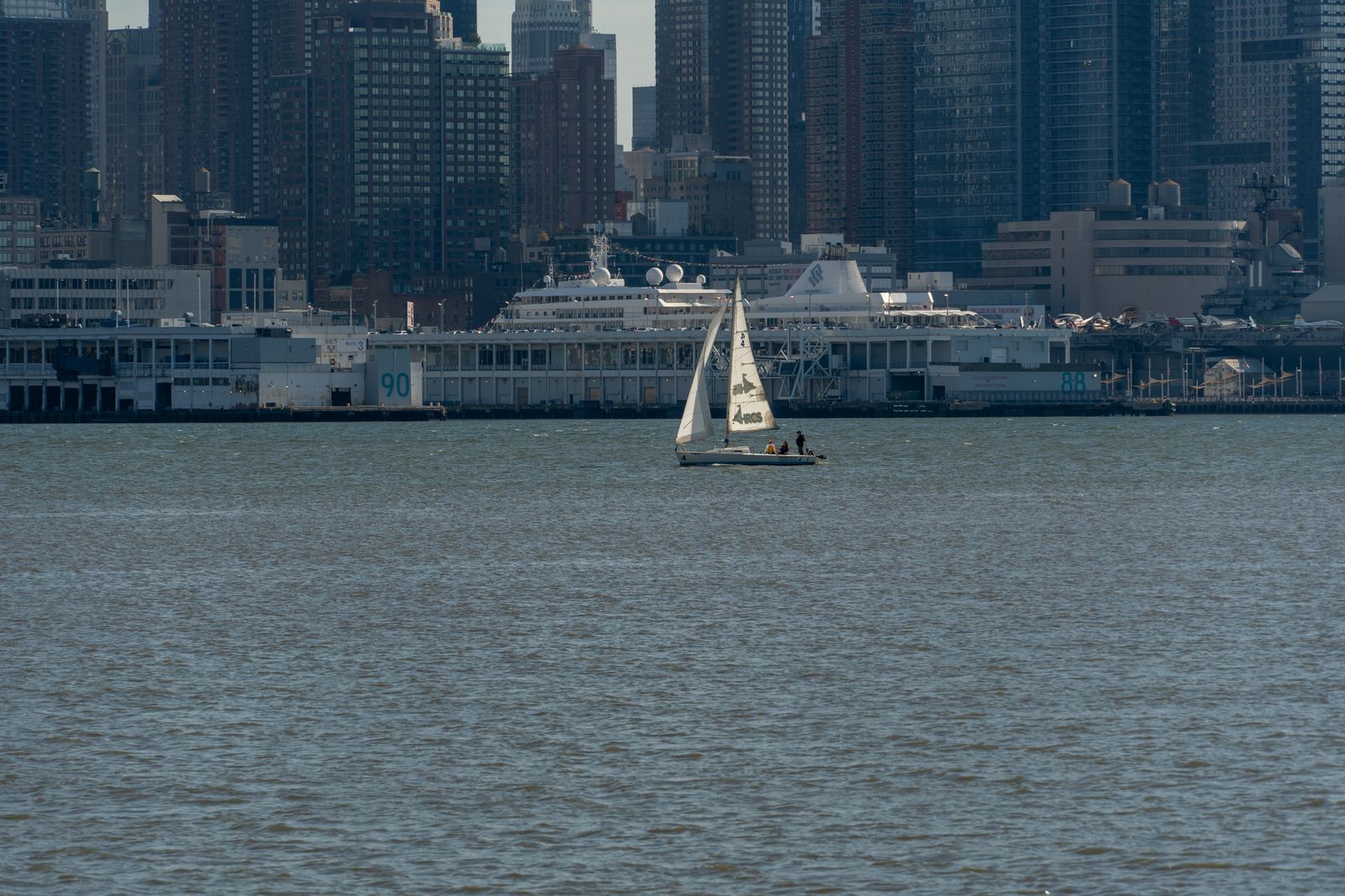 Sailboat on the water with the Manhattan skyline behind