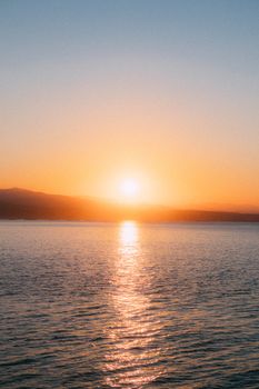 A breathtaking sunset casting warm hues over a tranquil ocean surface.