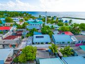 A vibrant aerial shot of Maabaidhoo village in the Maldives showcasing colorful rooftops and lush greenery.