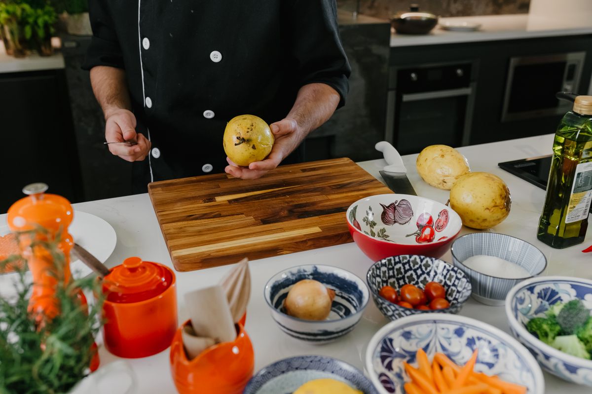 Fresh ingredients being prepared with a knife on a wooden cutting board