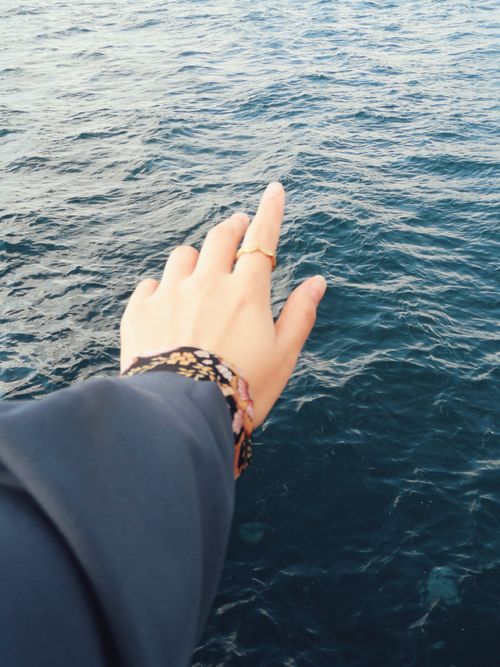 Free A hand reaching over the calm ocean, symbolizing freedom and exploration. Stock Photo