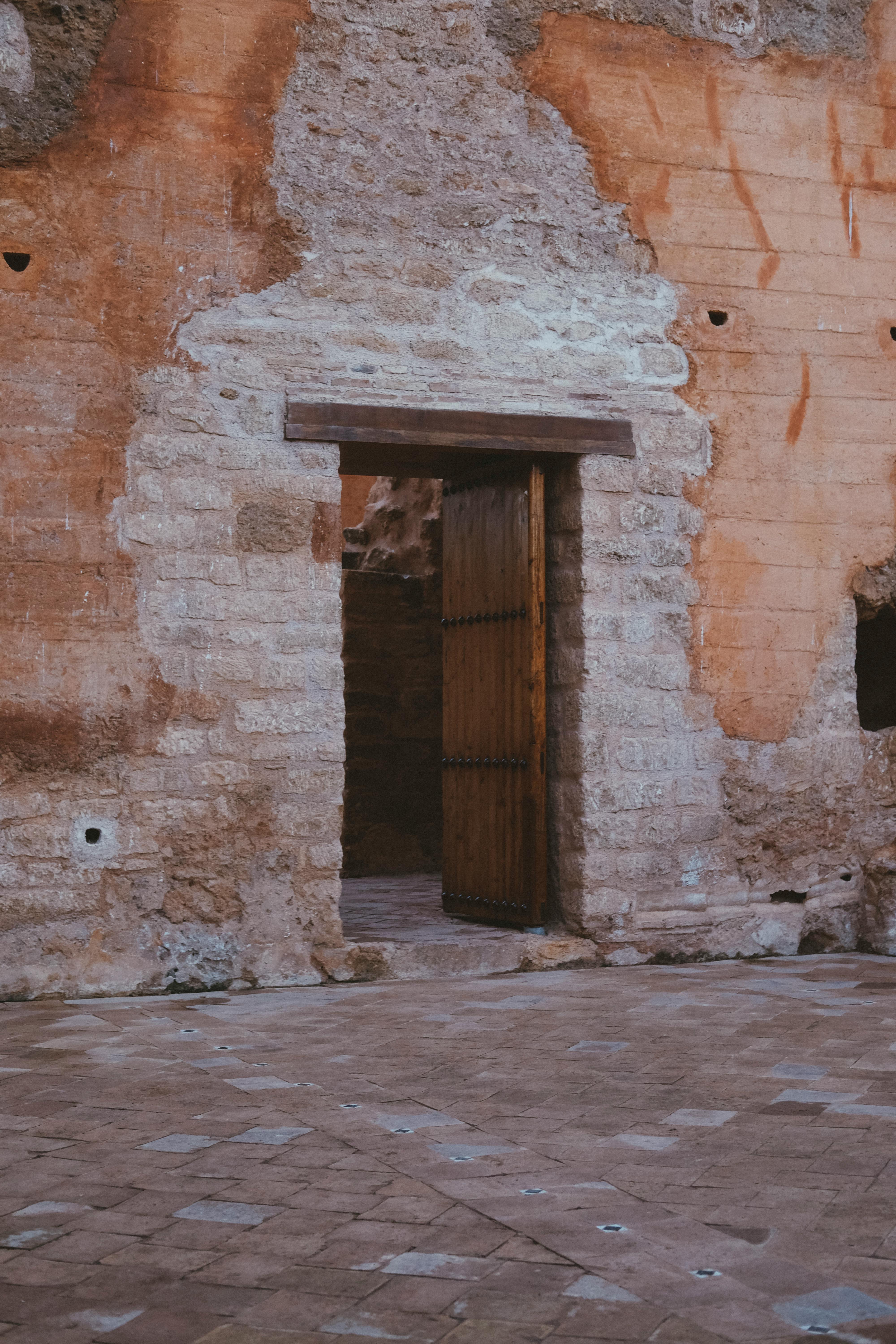 A rustic stone wall with a wooden doorway in Rabat, Morocco, showcasing ancient architecture.