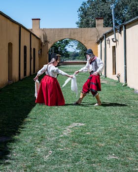 Two gauchos in traditional attire perform a dance outdoors in Chascomús, Argentina.