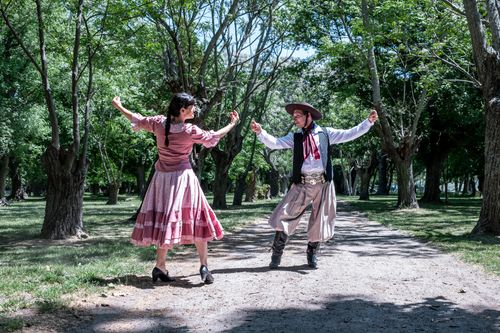 Free A couple performs a traditional gaucho dance in a sunny park in Chascomús, Argentina. Stock Photo
