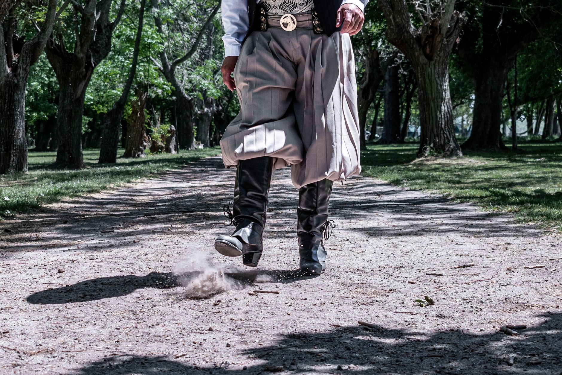 Gaucho in traditional attire striking a pose on a dusty path in Chascomús, Argentina.