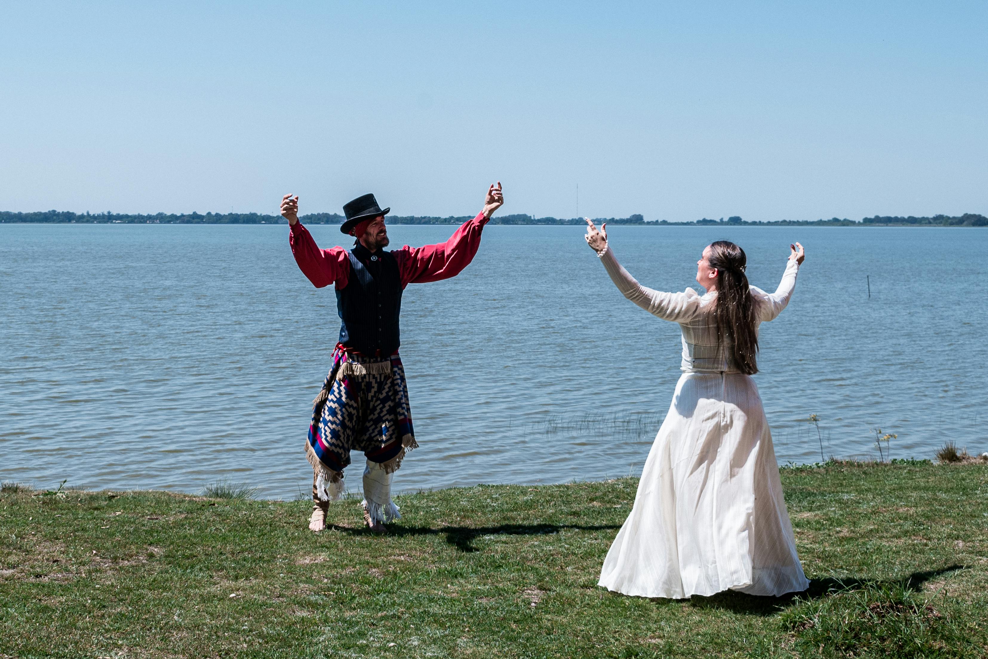 Free Gauchos perform a traditional dance on the grassy shores of Chascomús Lake, Argentina. Stock Photo