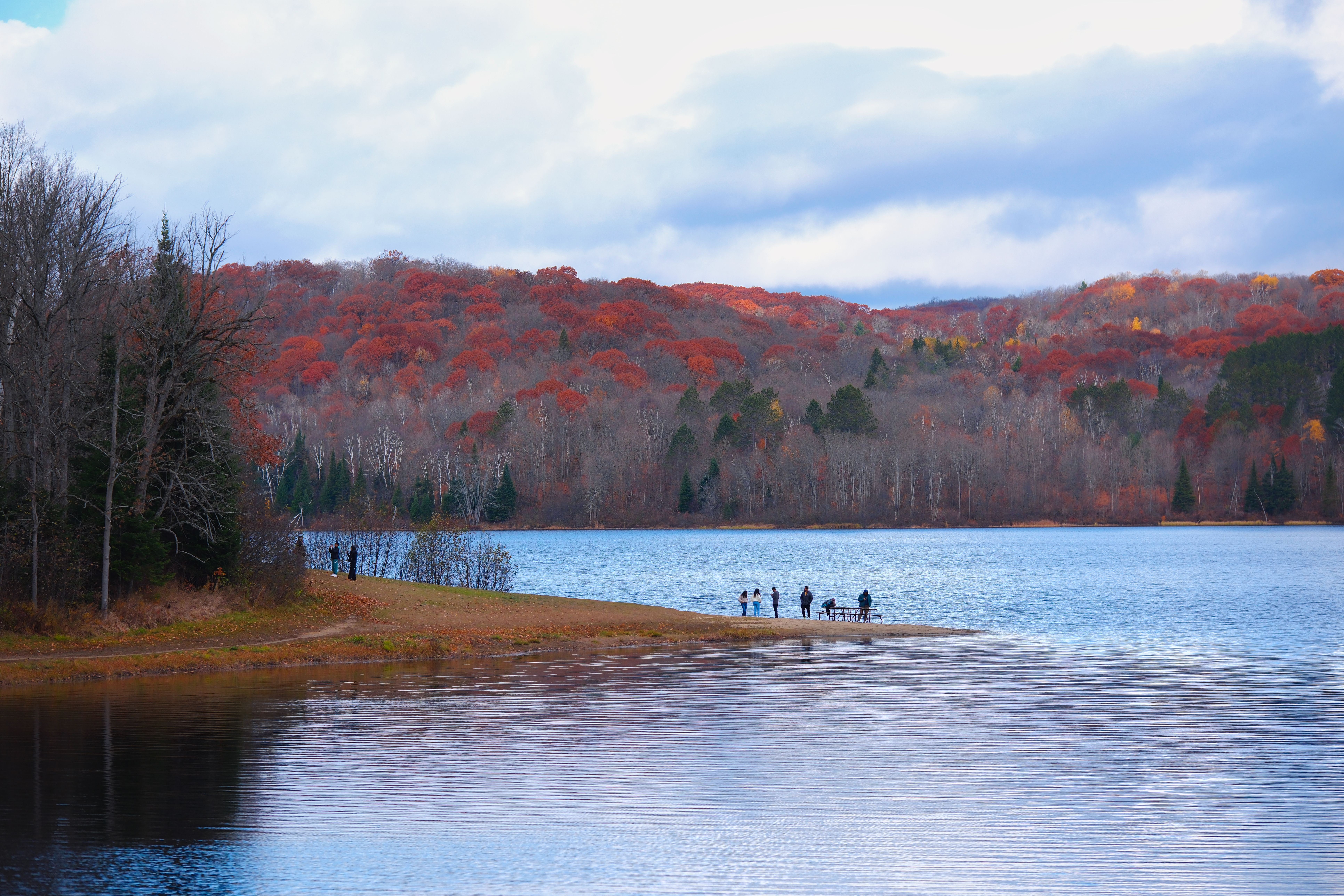 Serene autumn scene by a lake in Huntsville, Ontario, showcasing vibrant foliage.