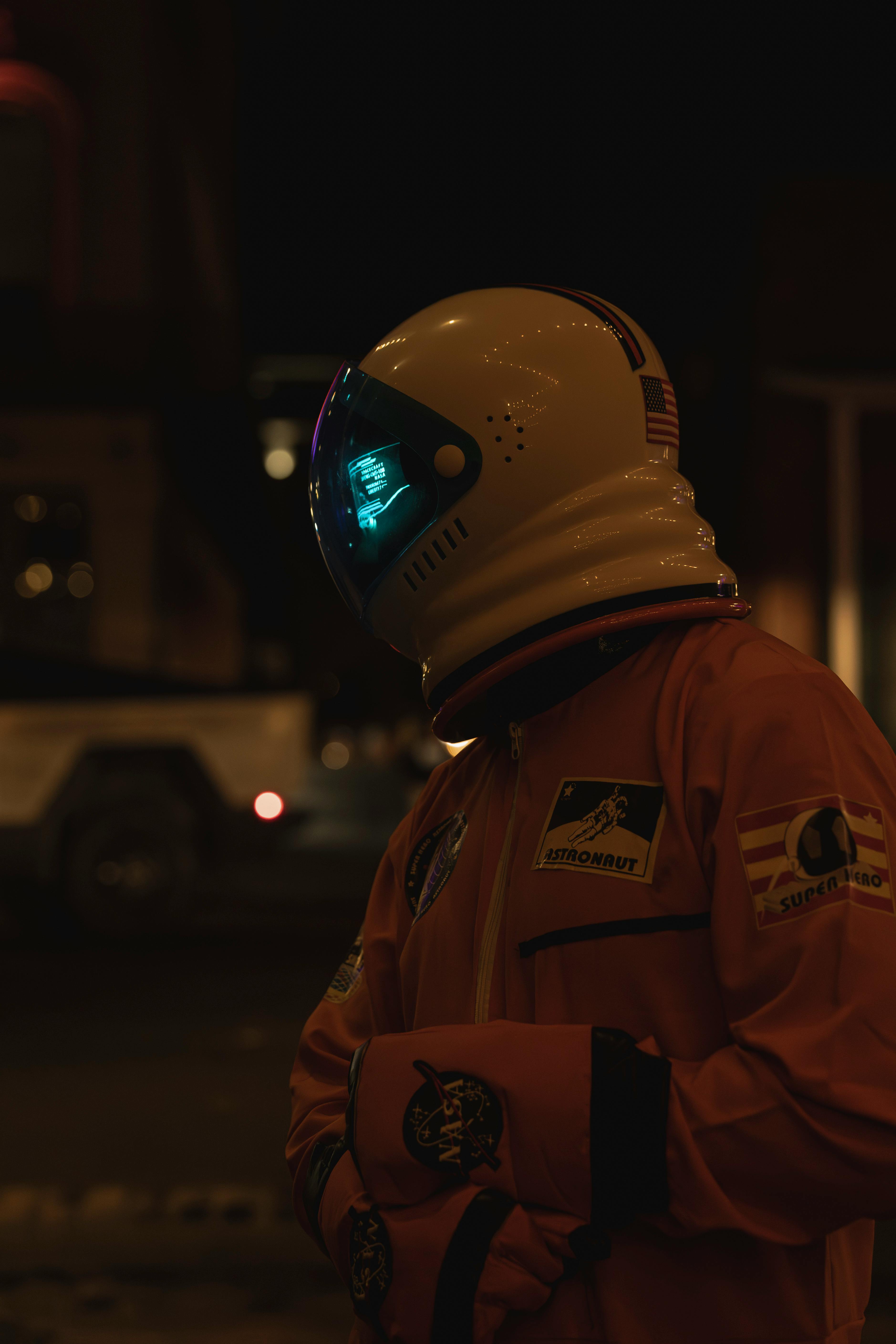 Astronaut figure in a suit with reflective helmet set in a nighttime urban environment, creating a futuristic vibe.
