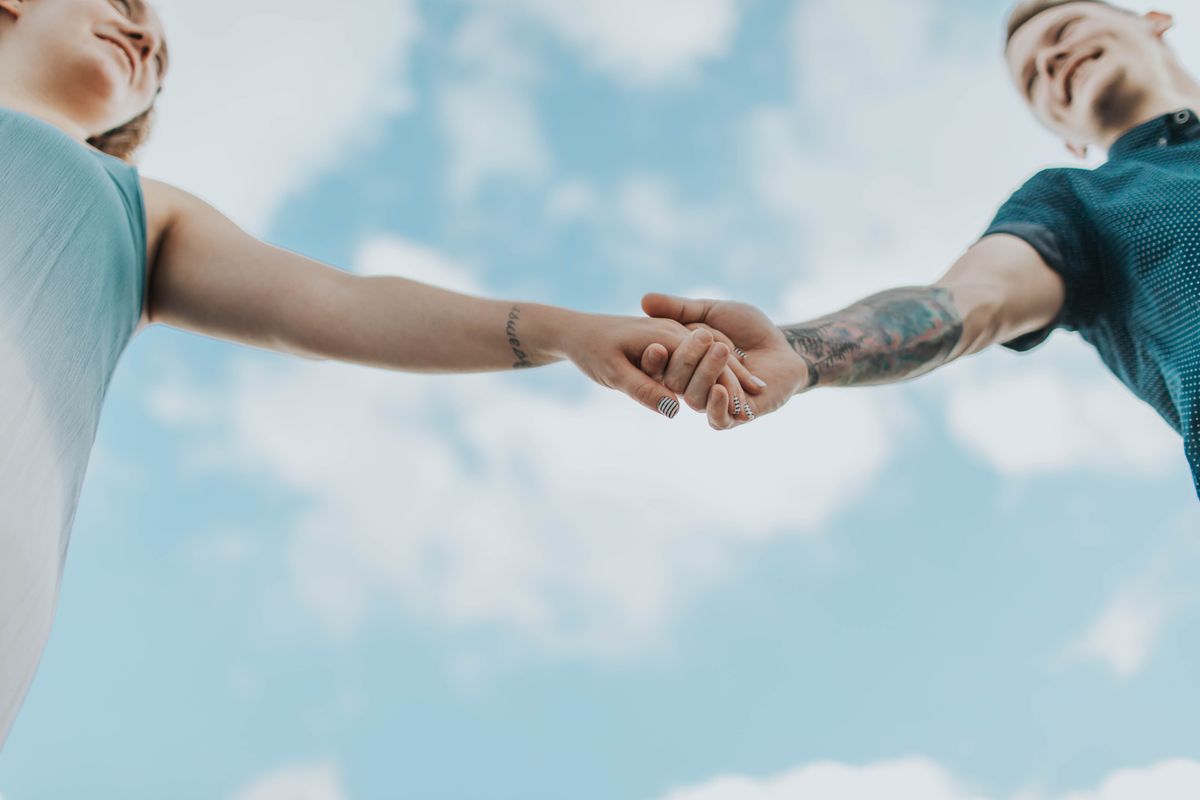 Man en vrouw die elkaars hand vastnemen