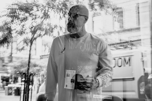 Gray-scale Photo of Man Holding Magazine