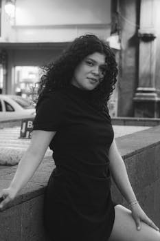 Black and white portrait of a woman in a cityscape with urban charm.
