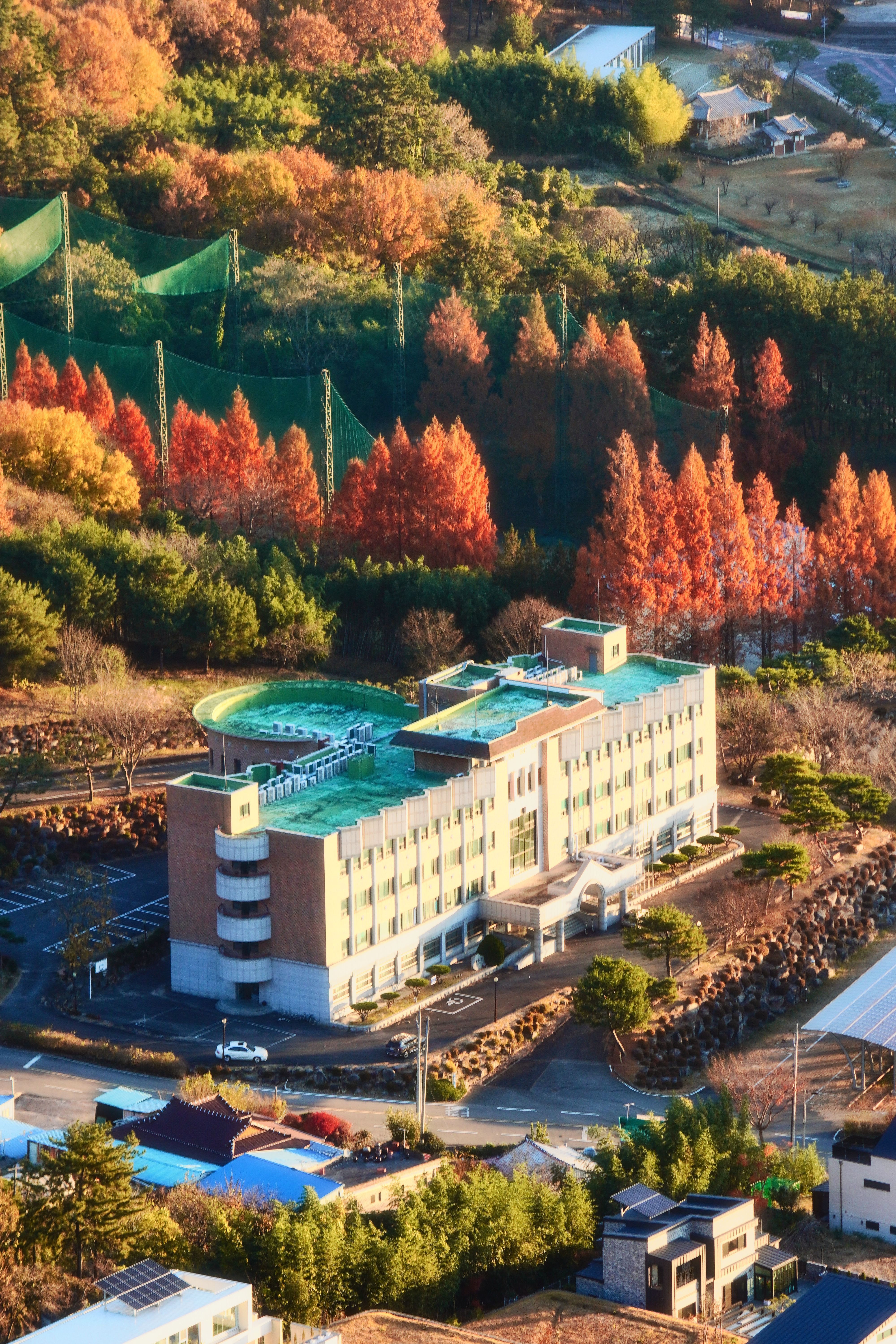 aerial view of building surrounded by colorful autumn trees