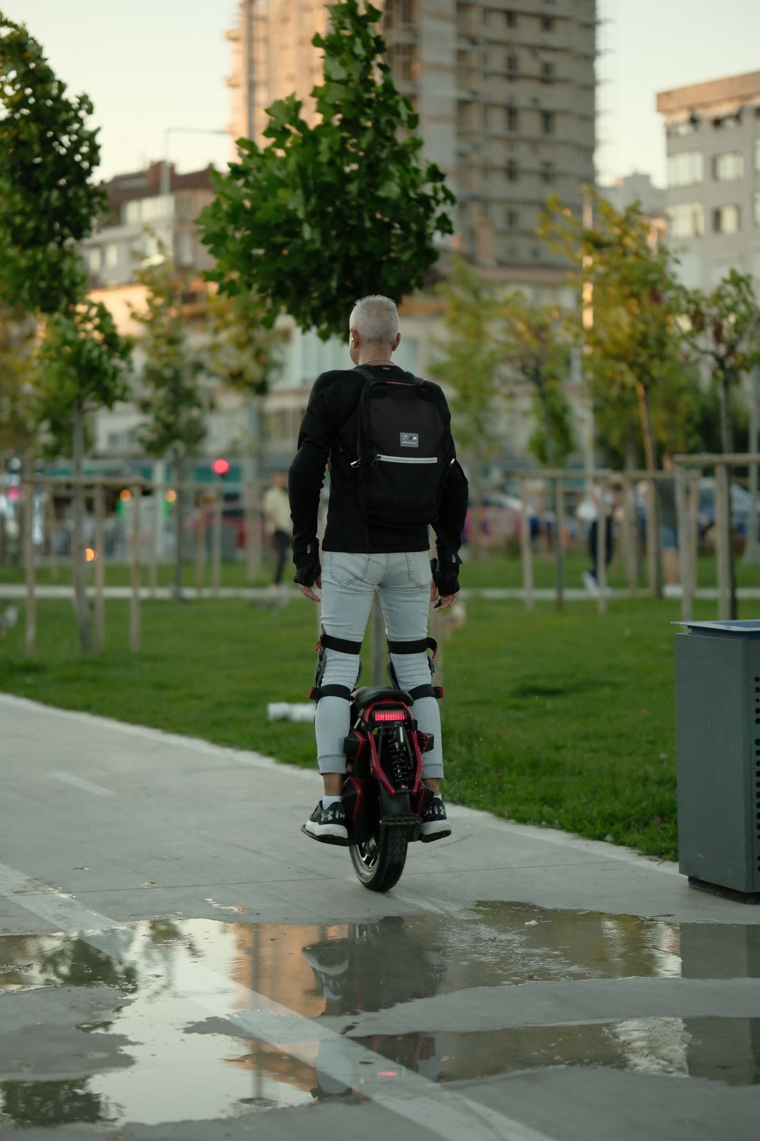 Person fährt mit einem elektrischen Einrad durch einen Park