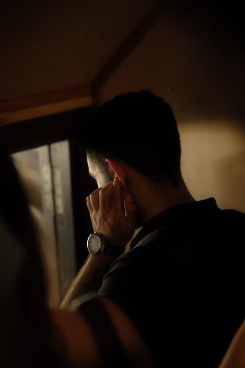 Free A man gazes thoughtfully out the window, deep in contemplation indoors. Stock Photo