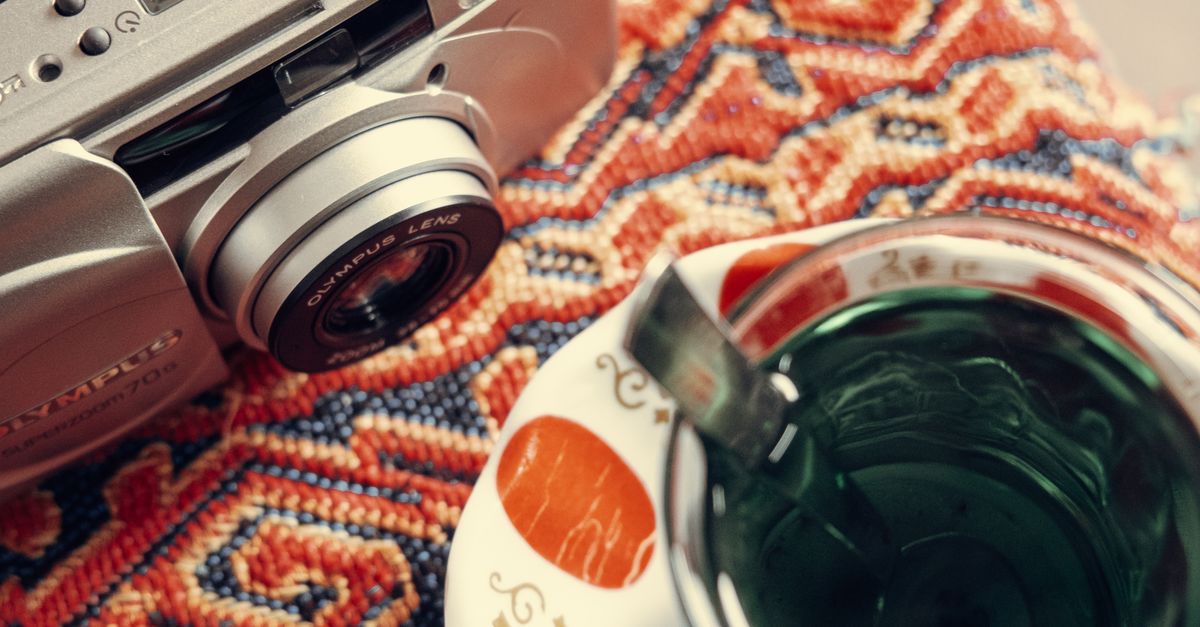 Vintage Camera and Tea on Patterned Fabric · Free Stock Photo