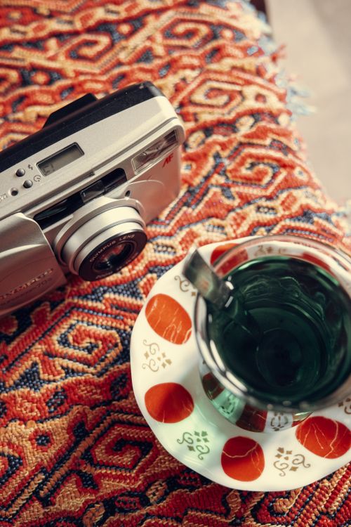 Vintage Camera and Tea on Patterned Fabric · Free Stock Photo