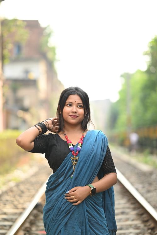 Free A South Asian woman in a sari standing on a railway track in Kolkata. Stock Photo