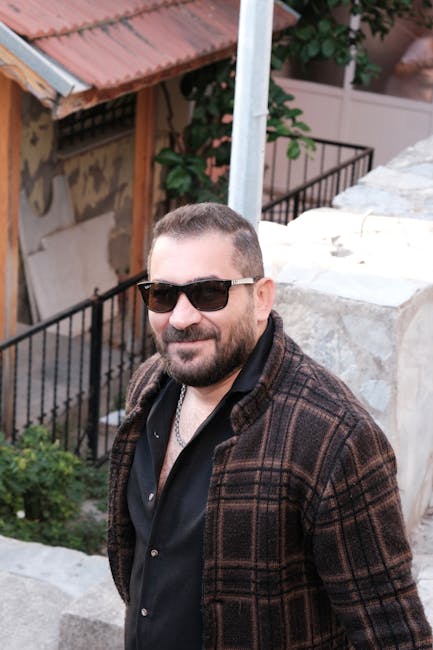 Casual portrait of a smiling man wearing sunglasses outdoors in İzmir, Türkiye.