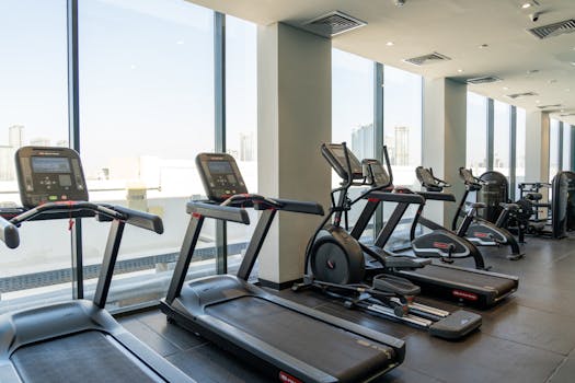 Spacious gym in Dubai equipped with modern treadmills and exercise bikes.