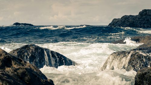 Free Capture of ocean waves crashing on rocky shore, showcasing nature's power and beauty. Stock Photo