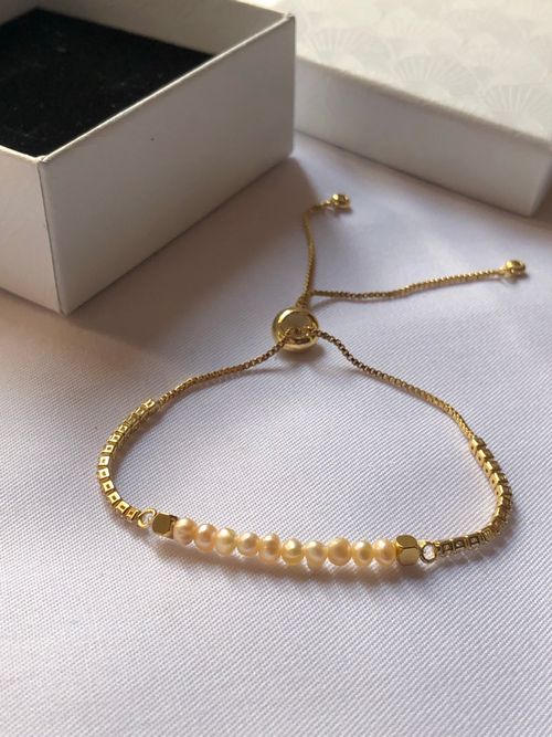 Free Minimalist bracelet with delicate pearls and gold chain, perfect for chic fashion. Stock Photo
