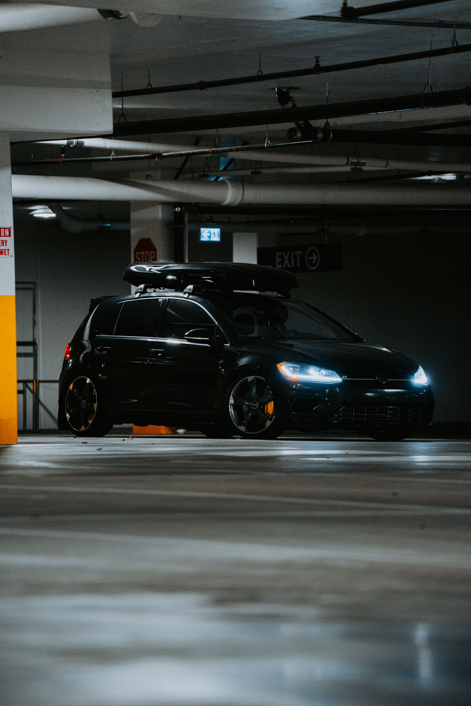 Compacte noire dans un parking éclairé