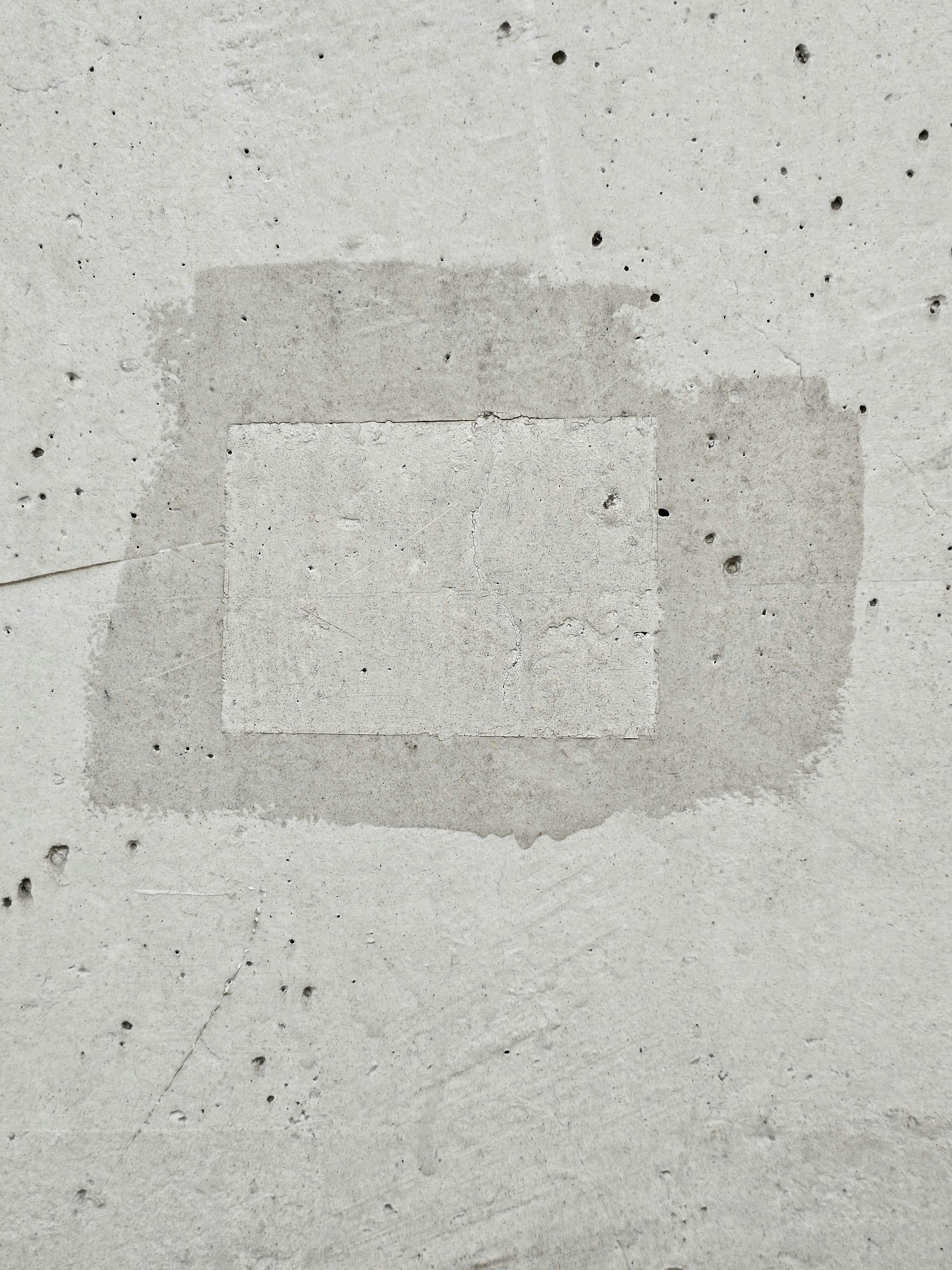 Free A close-up of a textured concrete wall showcasing a rough patchwork design. Stock Photo
