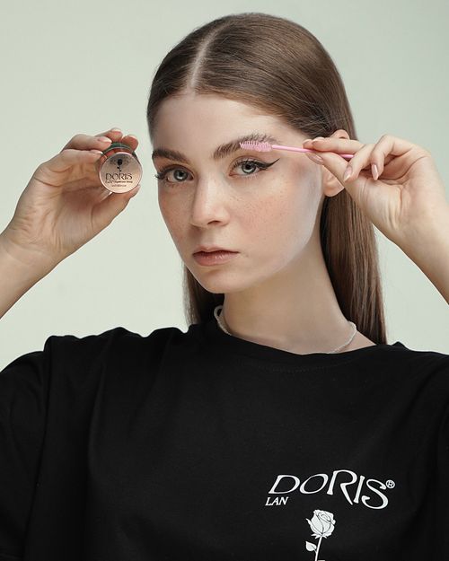 Free Close-up of a young woman using a brush for eyebrow makeup, featuring a minimalist style. Stock Photo