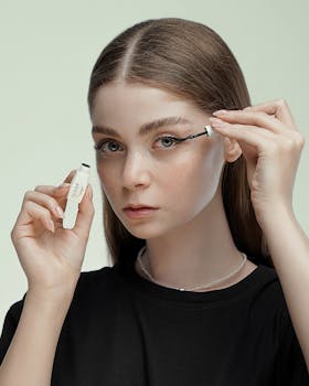 Close-up of a young woman applying mascara, emphasizing eyes and beauty routine.