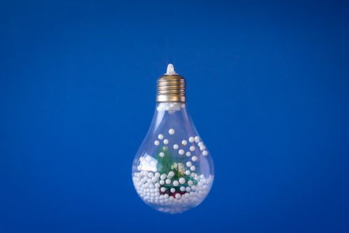 Free A light bulb filled with a snowy scene against a blue background, symbolizing creative ideas. Stock Photo