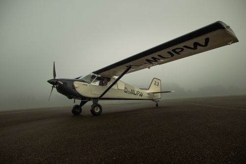 Free A small aircraft parked on a foggy runway at dawn, showcasing aviation tranquility. Stock Photo