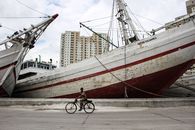 Man Riding Bike Beside Ship
