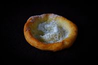 Delicious pastry with powdered sugar on a dark background, perfect for dessert imagery.