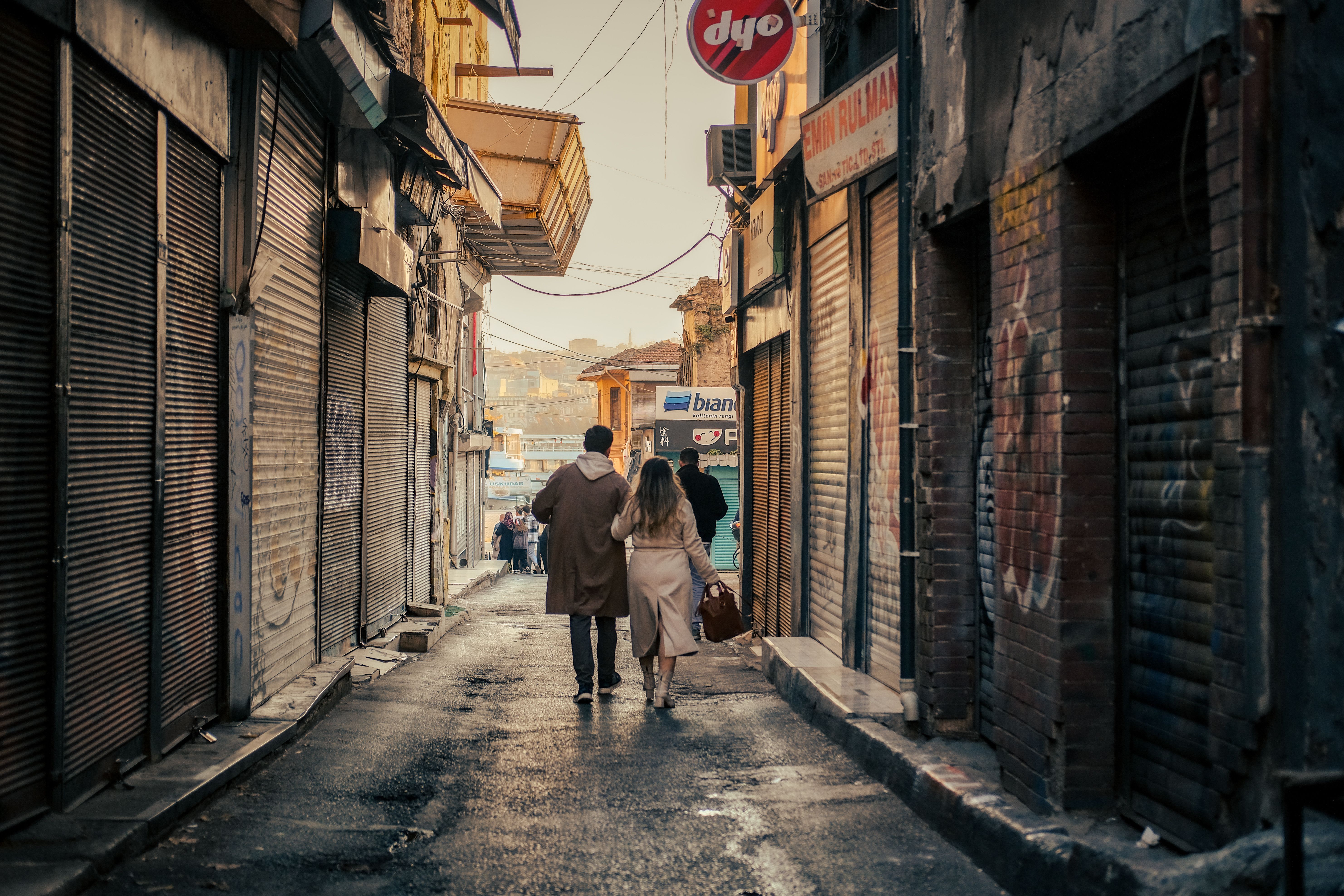Couple Walking in Narrow Urban Alleyway · Free Stock Photo