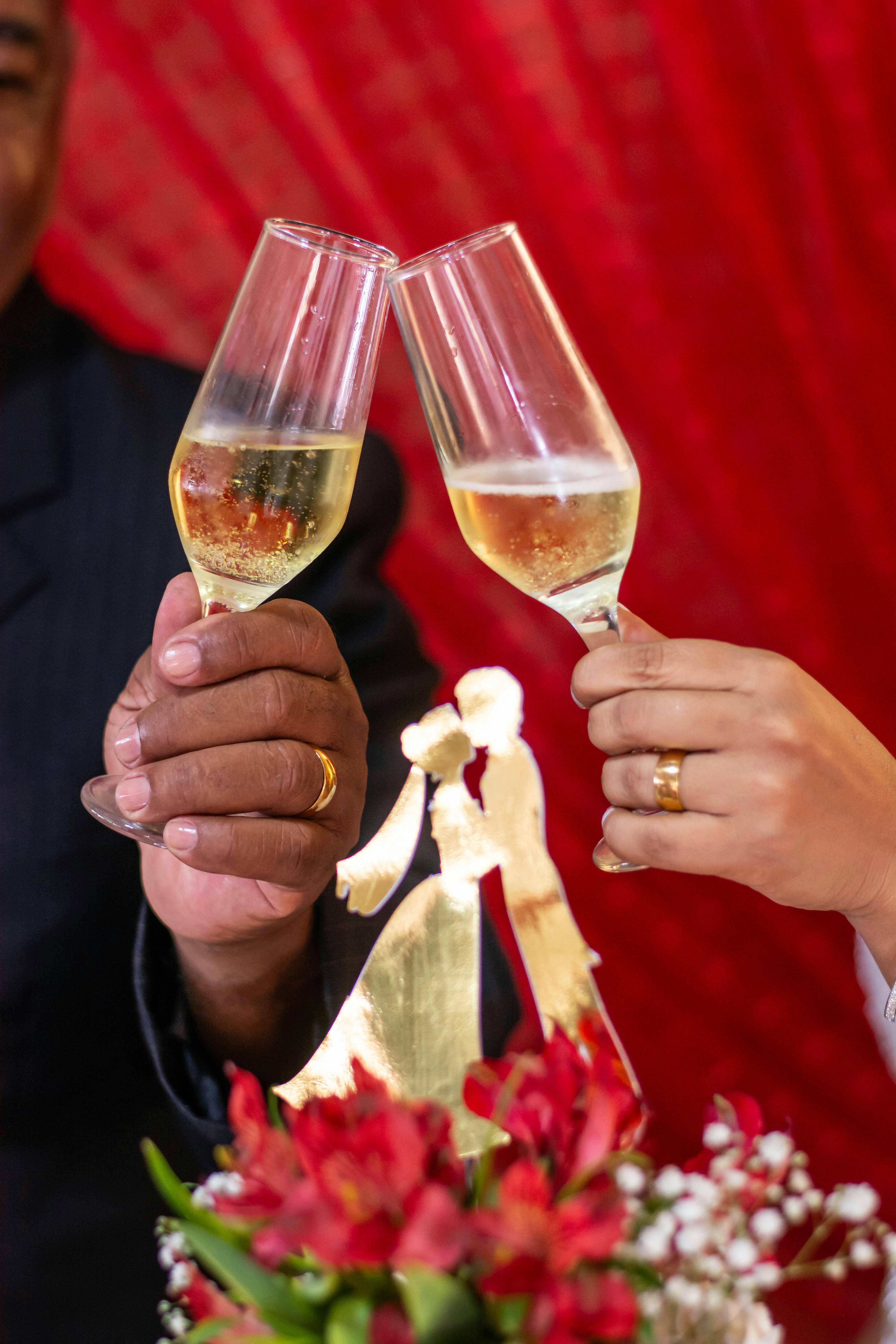 Close-up of a couple toasting with champagne glasses at a wedding celebration.