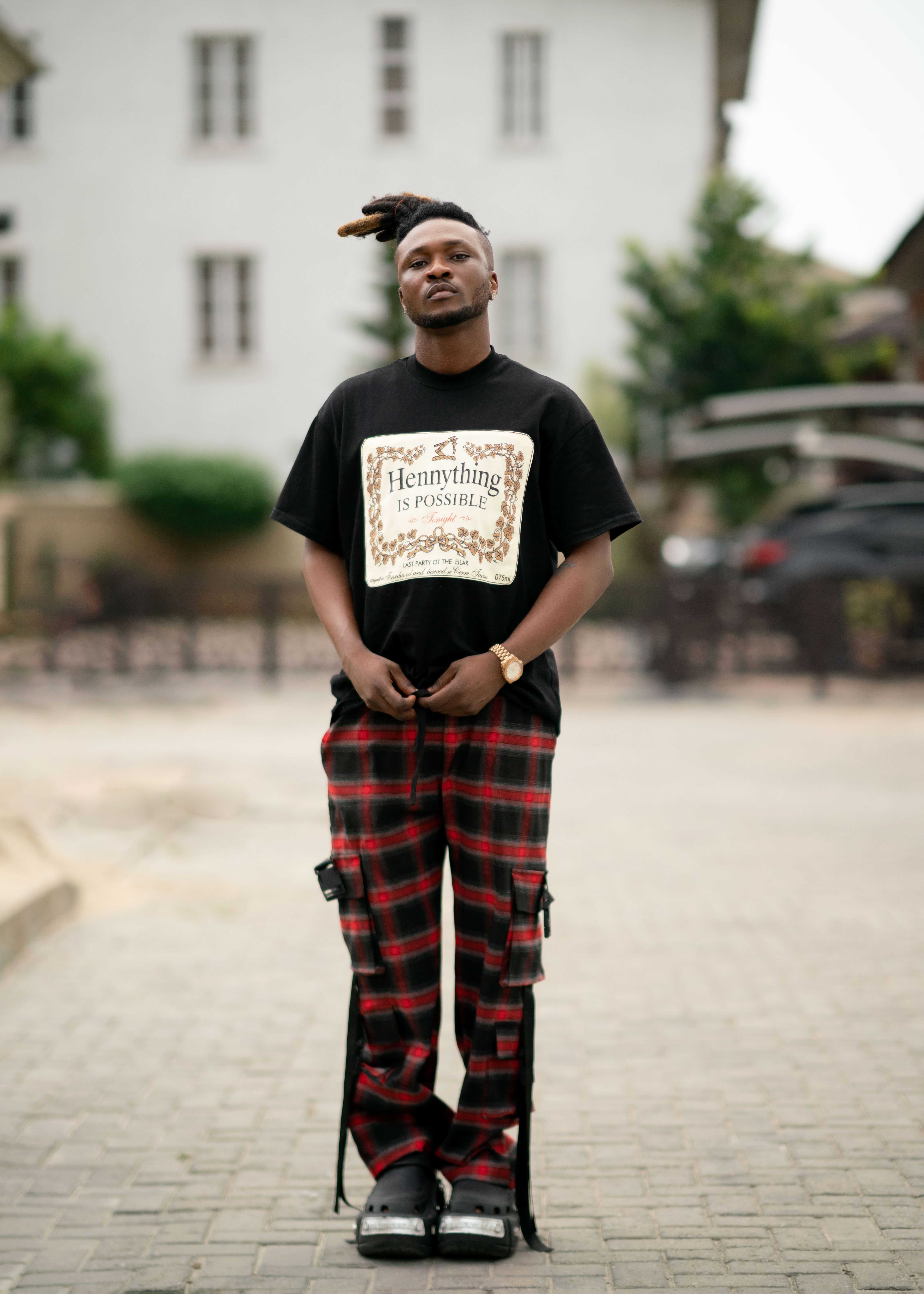 Trendy street style featuring graphic tee and checkered pants in an urban setting.