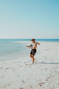 A relaxed man dances on a sunny beach, capturing the essence of a carefree summer day.