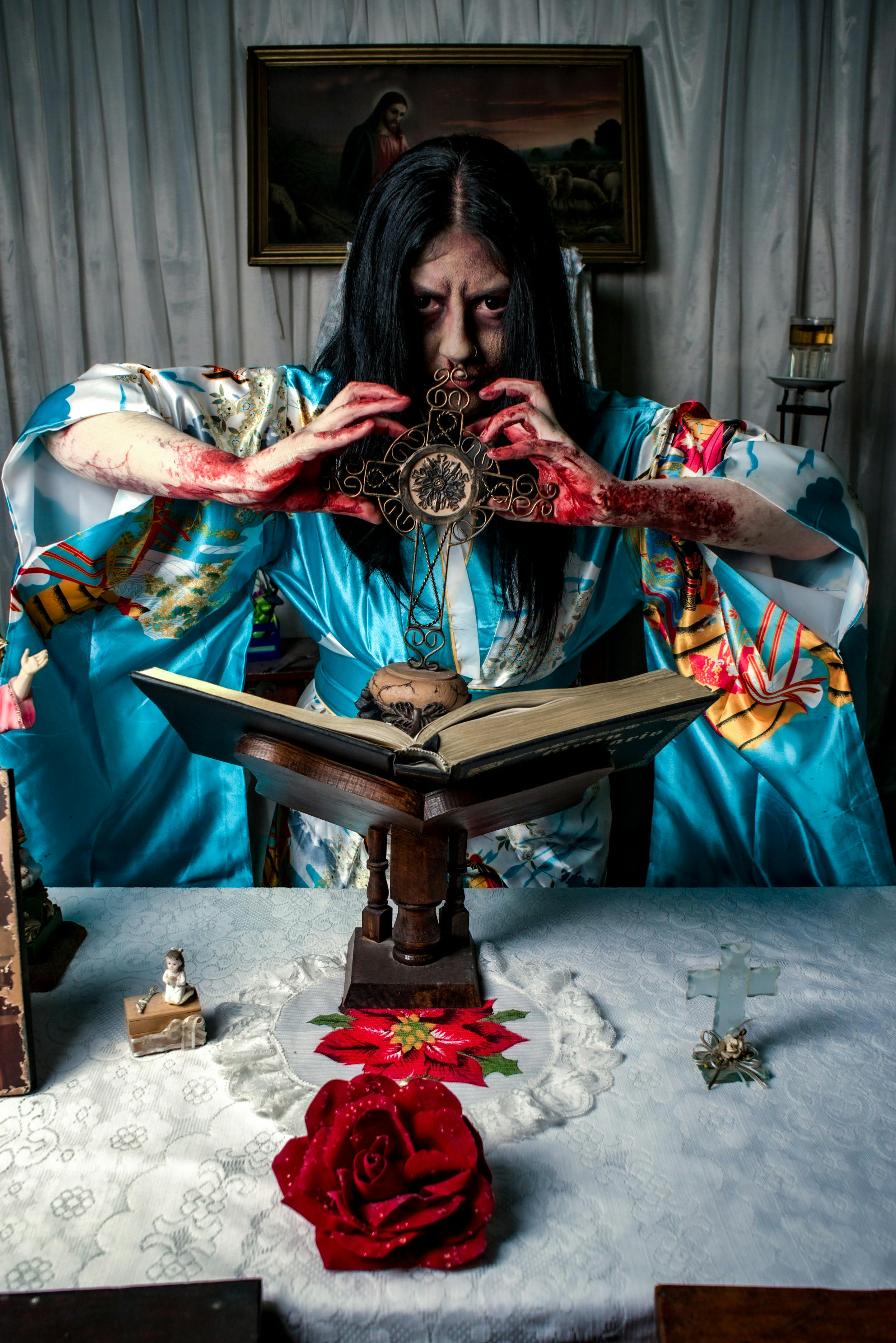 dramatic portrait of woman in blue kimono with cross