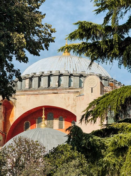 Free The iconic dome of Hagia Sophia emerges gracefully amidst vibrant trees, showcasing architectural grandeur. Stock Photo