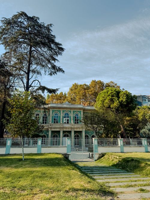Free A classic two-story building amidst lush trees on a sunny day in Istanbul. Stock Photo