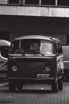 Black and white photograph of a vintage Volkswagen van parked in a city street.
