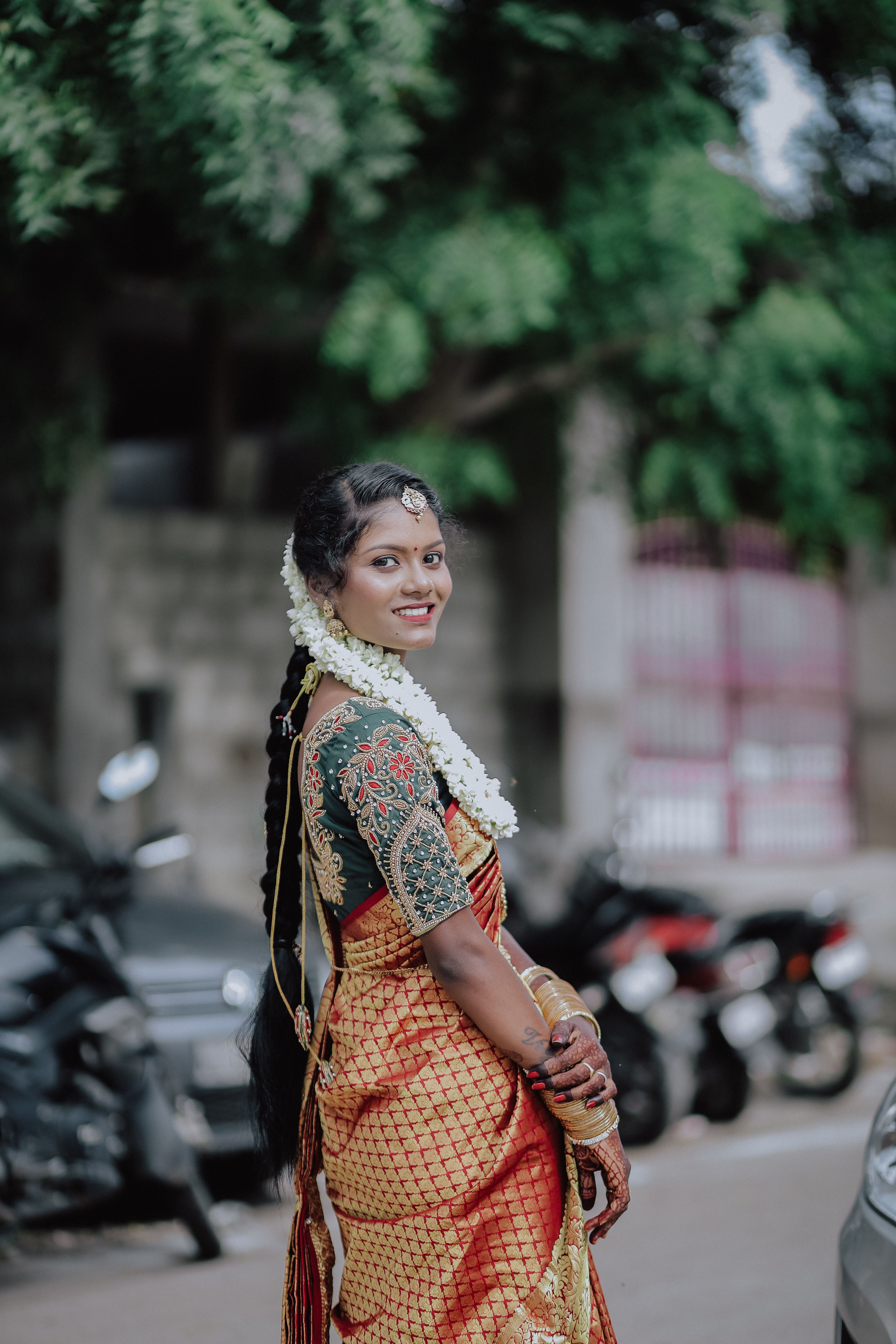 A stunning Indian bride in traditional attire with intricate details and floral accessories.