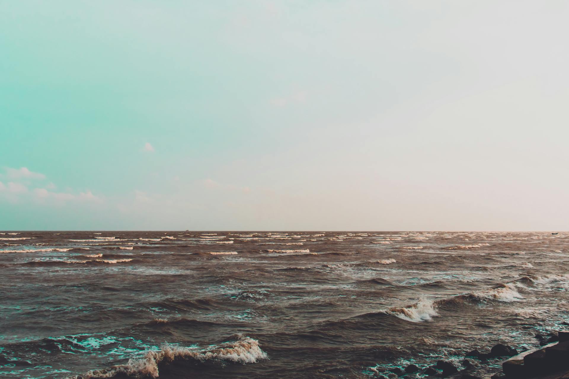 Serene ocean waves under a pastel sky in East Medinipur, India during sunset.